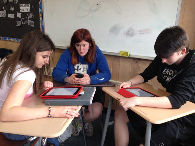 Students working collaboratively to finish a project with the use of iPads.