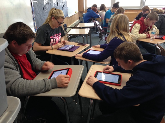 Students working collaboratively to finish a project with the use of iPads.